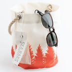 White bag with red and white tree design, sunglasses hanging out, and 'SEABAGS' tag.