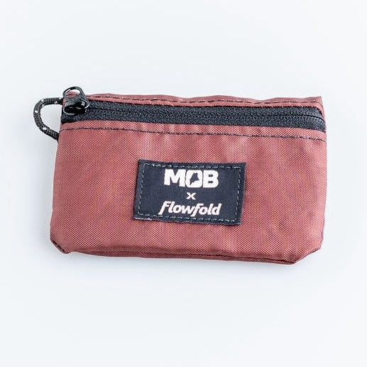 Red zippered pouch with Flowfold logo on a white background